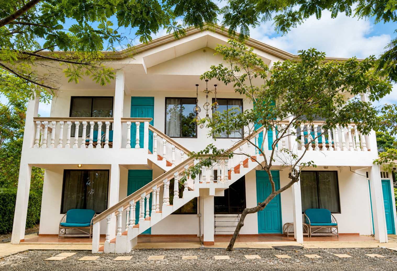 Eco Apartments Uvita — white two-storey building with turquoise doors and balconies